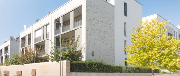 Mehrfamilienhaus mit Weg und Bänken
